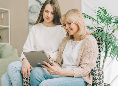 Mother and adult daughter using digital tablet